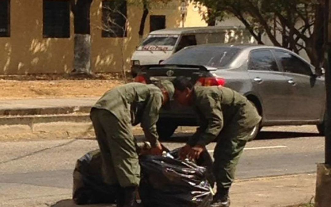 Soldados registran bolsa de basura en busca de comida